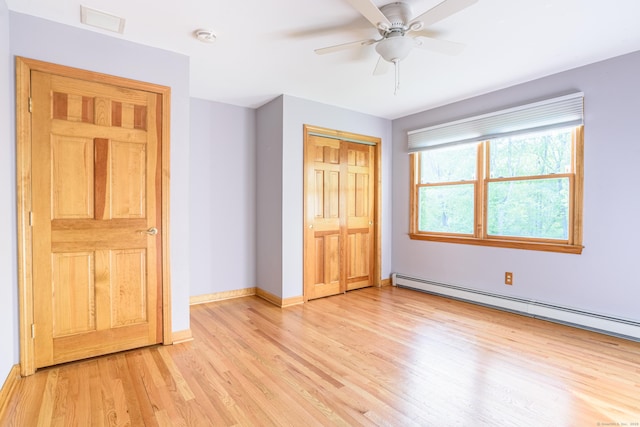 unfurnished bedroom with a baseboard heating unit, light wood-style floors, a closet, baseboards, and a ceiling fan