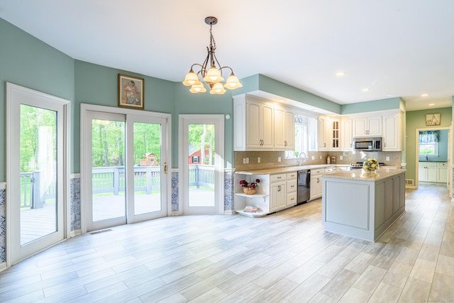 43 Roaring Brook Ln, Shelton, CT 06484 - kitchen with dishwashing machine, stainless steel microwave, stove, a chandelier, and plenty of natural light