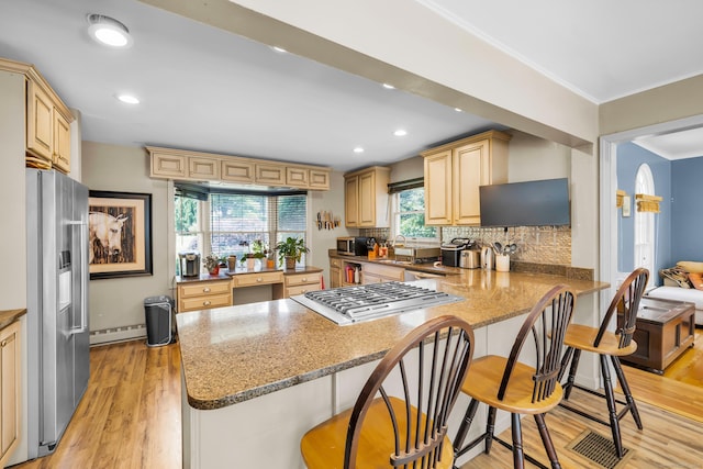 10 Harvard Ter, Norwich, CT 06360 - kitchen with appliances with stainless steel finishes, a peninsula, light wood finished floors, a kitchen breakfast bar, and decorative backsplash