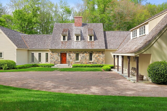 70 Sill Ln, Old Lyme, CT 06371 - new england style home featuring a chimney, stone siding, and a front yard