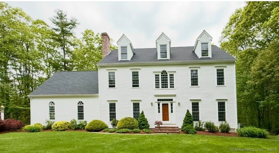 view of front of house with a front yard and a chimney