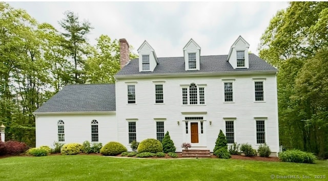 view of front of house with a front yard and a chimney