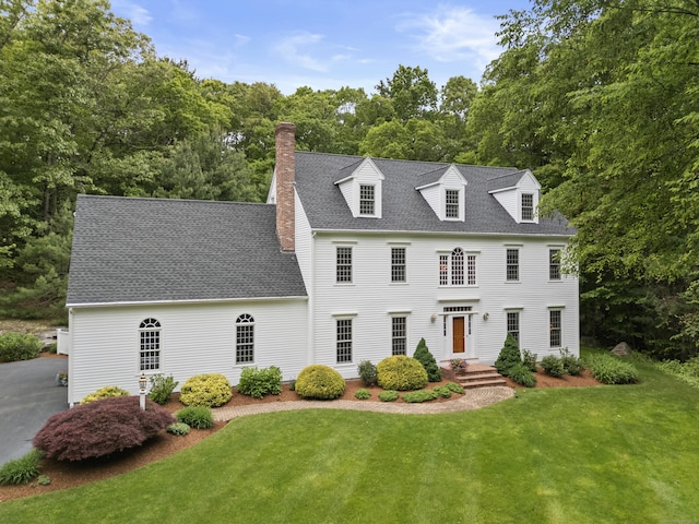 262 Fairview Rd, Westbrook, CT 06498 - view of front facade with a front yard, a chimney, roof with shingles, and view of wooded area