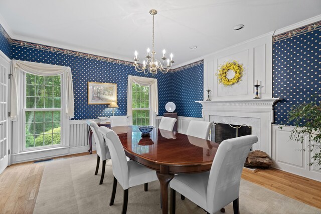262 Fairview Rd, Westbrook, CT 06498 - dining space featuring wallpapered walls, a chandelier, ornamental molding, light wood-style floors, and a decorative wall