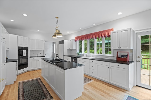 262 Fairview Rd, Westbrook, CT 06498 - kitchen featuring black appliances, a kitchen island, healthy amount of natural light, dark countertops, and recessed lighting