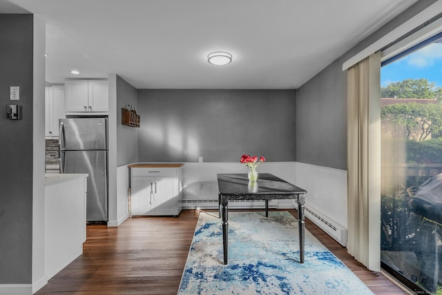 dining space with dark wood-type flooring, baseboard heating, recessed lighting, and baseboards