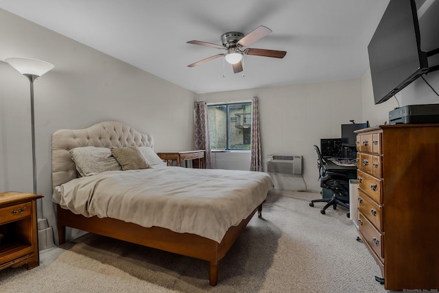 bedroom featuring a wall mounted AC, an office area, light colored carpet, and a ceiling fan