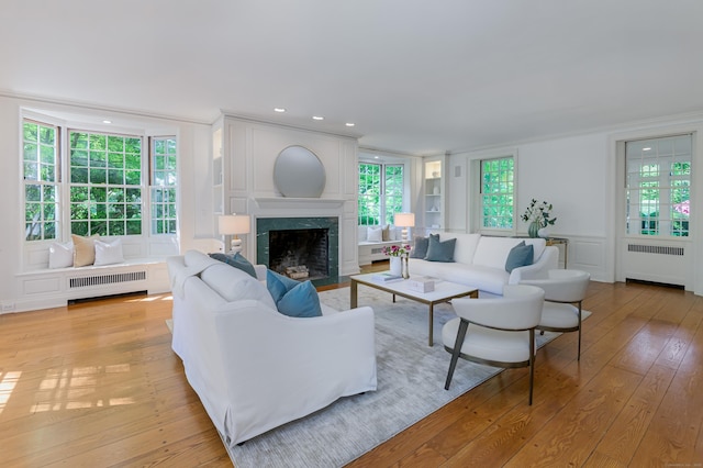 379 Hurlbutt St, Wilton, CT 06897 - living area with radiator heating unit, ornamental molding, light wood-type flooring, a premium fireplace, and a decorative wall