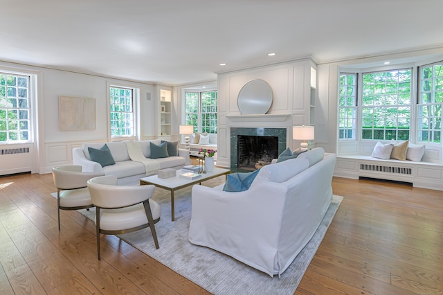 379 Hurlbutt St, Wilton, CT 06897 - living room with radiator, a premium fireplace, a decorative wall, wood-type flooring, and recessed lighting