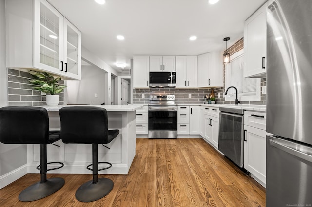 20 Rosengarten Dr, Waterbury, CT 06704 - kitchen with stainless steel appliances, a kitchen breakfast bar, light countertops, tasteful backsplash, and recessed lighting