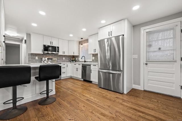 20 Rosengarten Dr, Waterbury, CT 06704 - kitchen with appliances with stainless steel finishes, light countertops, a sink, decorative backsplash, and white cabinets
