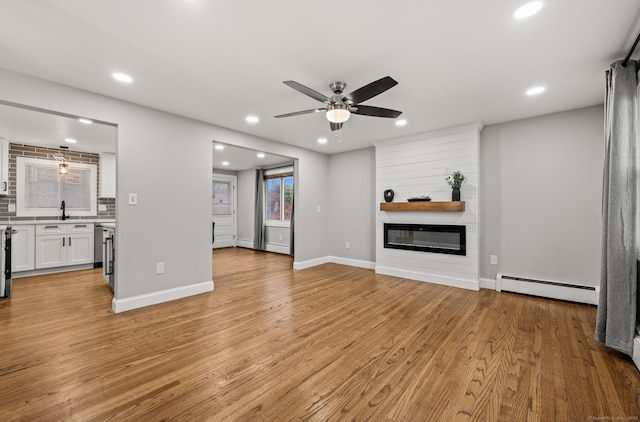 20 Rosengarten Dr, Waterbury, CT 06704 - unfurnished living room featuring baseboard heating, a ceiling fan, recessed lighting, light wood-style floors, and a large fireplace