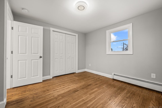20 Rosengarten Dr, Waterbury, CT 06704 - unfurnished bedroom with wood finished floors, baseboards, a closet, and a baseboard radiator