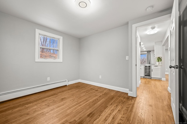 20 Rosengarten Dr, Waterbury, CT 06704 - empty room with a baseboard heating unit, wine cooler, a smoke detector, light wood finished floors, and baseboards