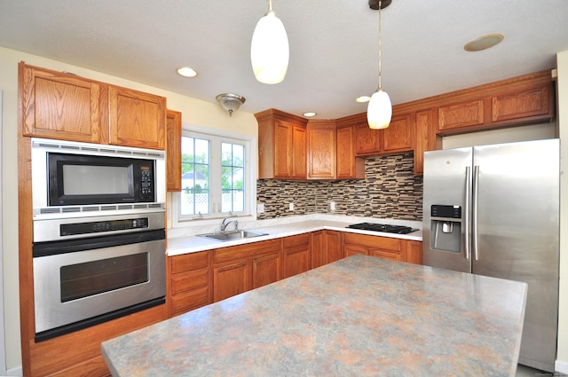20 Nessa Way, Rocky Hill, CT 06067 - kitchen featuring appliances with stainless steel finishes, a sink, decorative backsplash, brown cabinetry, and pendant lighting