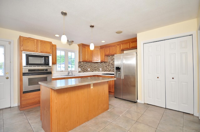 20 Nessa Way, Rocky Hill, CT 06067 - kitchen with appliances with stainless steel finishes, a center island, decorative backsplash, light tile patterned flooring, and light countertops