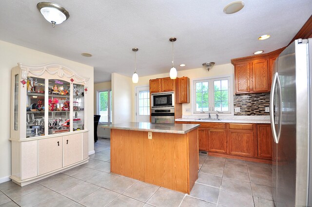 20 Nessa Way, Rocky Hill, CT 06067 - kitchen featuring stainless steel appliances, a sink, a center island, brown cabinetry, and pendant lighting
