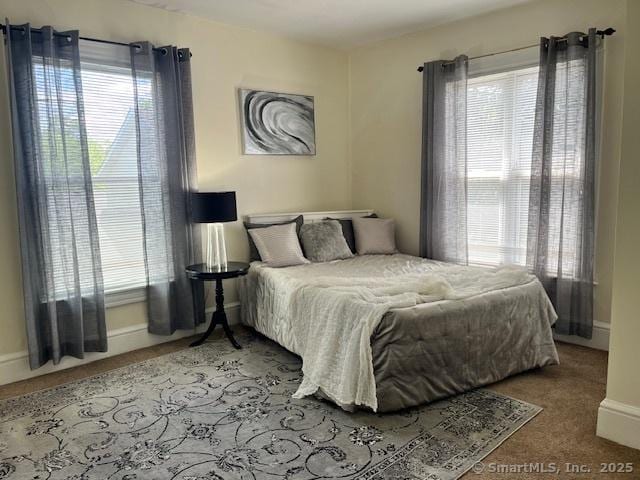 carpeted bedroom featuring baseboards