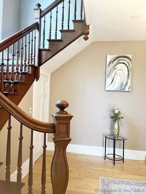 stairs featuring wood finished floors and baseboards