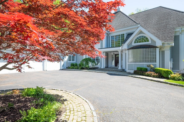 14 Dillman Ct, Ridgefield, CT 06877 - view of front of house with roof with shingles, curved driveway, and a porch