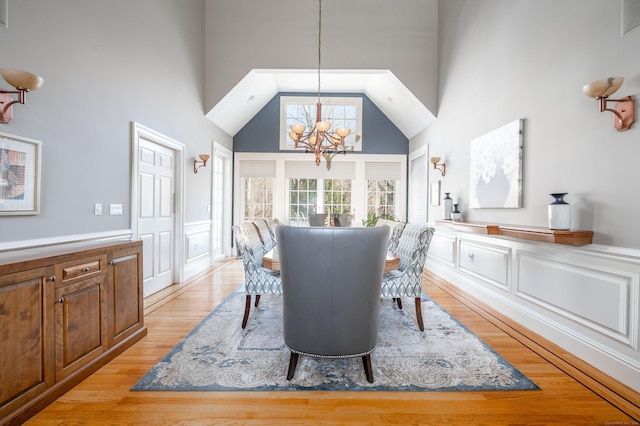 14 Dillman Ct, Ridgefield, CT 06877 - dining space with a high ceiling, a chandelier, a decorative wall, light wood-type flooring, and a wainscoted wall