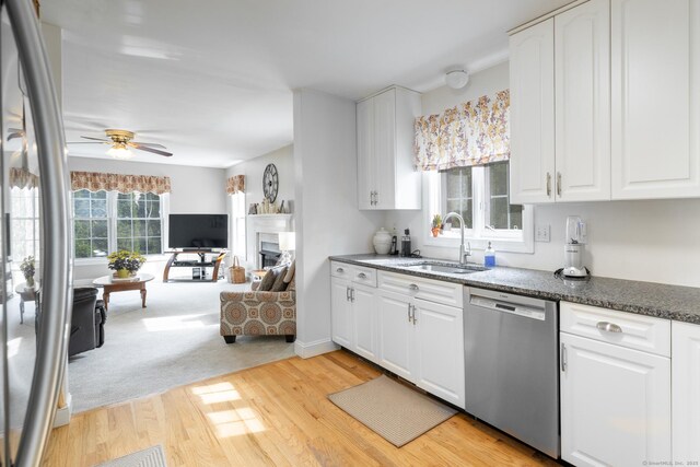 191 Pond View Dr, Watertown, CT 06795 - kitchen with stainless steel dishwasher, a sink, light wood-style flooring, open floor plan, and a ceiling fan