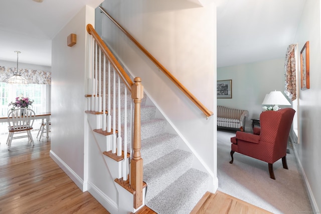 191 Pond View Dr, Watertown, CT 06795 - stairway featuring wood finished floors, baseboards, and a chandelier