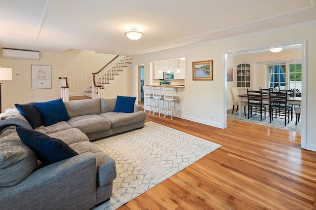 94 Mulberry St, Stamford, CT 06907 - living area with a wall mounted air conditioner, stairway, crown molding, wood finished floors, and bar area