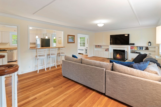 94 Mulberry St, Stamford, CT 06907 - living area with light wood-type flooring, a warm lit fireplace, and ornamental molding