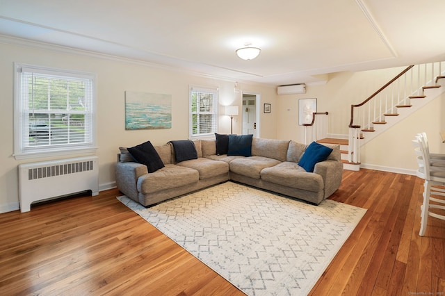 94 Mulberry St, Stamford, CT 06907 - living area featuring radiator, hardwood / wood-style flooring, an AC wall unit, stairs, and ornamental molding
