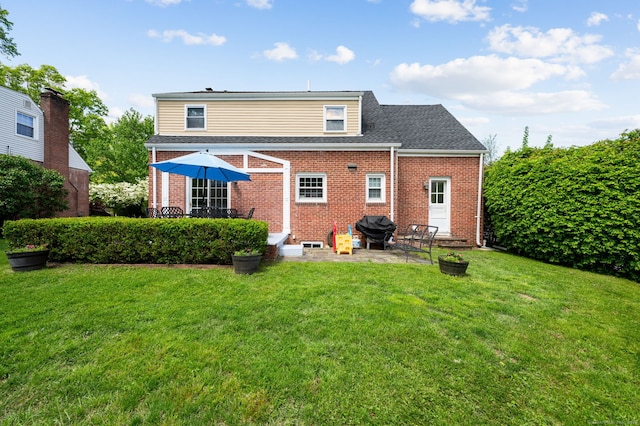 94 Mulberry St, Stamford, CT 06907 - rear view of house featuring brick siding, a yard, and a patio