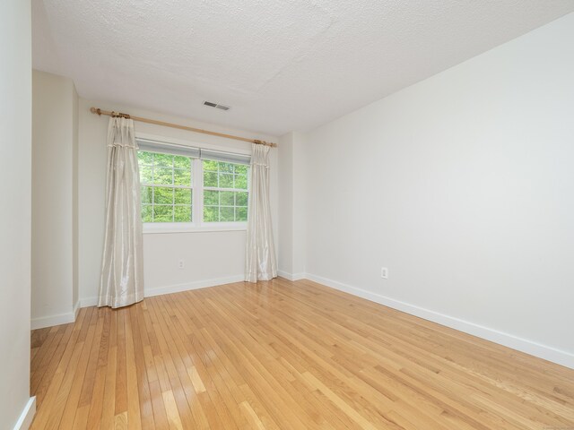 24 Wilton Crst Unit 24, Wilton, CT 06897 - spare room with light wood-type flooring, baseboards, and a textured ceiling