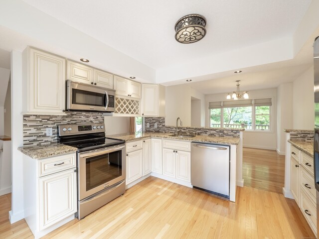 24 Wilton Crst Unit 24, Wilton, CT 06897 - kitchen with stainless steel appliances, a sink, light wood-type flooring, decorative backsplash, and recessed lighting