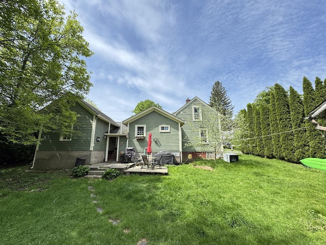rear view of house featuring a yard, a patio, and a chimney