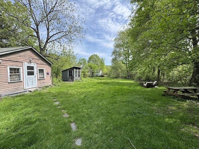 view of grassy yard with an outdoor structure