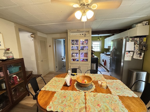dining space with ceiling fan and light wood-type flooring