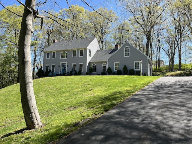 27 Regency Dr, North Haven, CT 06473 - colonial-style house featuring a chimney, a front lawn, and asphalt driveway