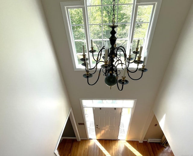27 Regency Dr, North Haven, CT 06473 - entrance foyer with a chandelier, a baseboard radiator, wood finished floors, a towering ceiling, and baseboards