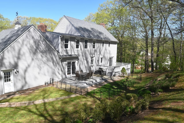 27 Regency Dr, North Haven, CT 06473 - back of property featuring a chimney, a gate, a patio, and roof with shingles