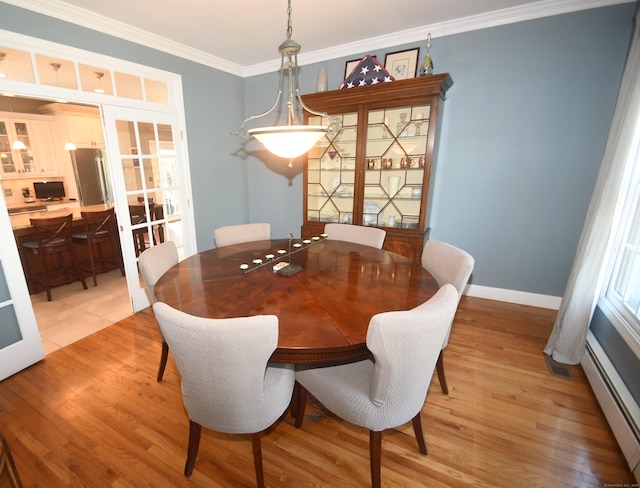 27 Regency Dr, North Haven, CT 06473 - dining space featuring baseboard heating, french doors, light wood-style flooring, ornamental molding, and baseboards