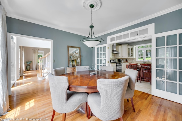 27 Regency Dr, North Haven, CT 06473 - dining space with plenty of natural light, ornamental molding, light wood-style flooring, and stairs