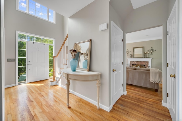 27 Regency Dr, North Haven, CT 06473 - foyer with light wood finished floors, stairs, a high ceiling, a fireplace, and baseboards