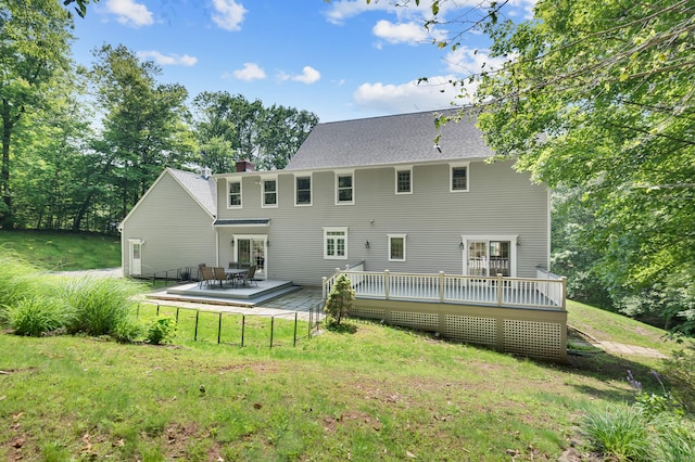 27 Regency Dr, North Haven, CT 06473 - rear view of house featuring a deck, a lawn, a chimney, and a shingled roof