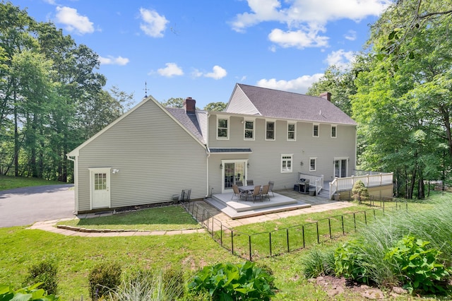 27 Regency Dr, North Haven, CT 06473 - rear view of property with a chimney, a deck, a shingled roof, and outdoor dining space