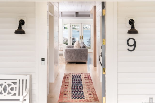 hallway with wood finished floors and french doors