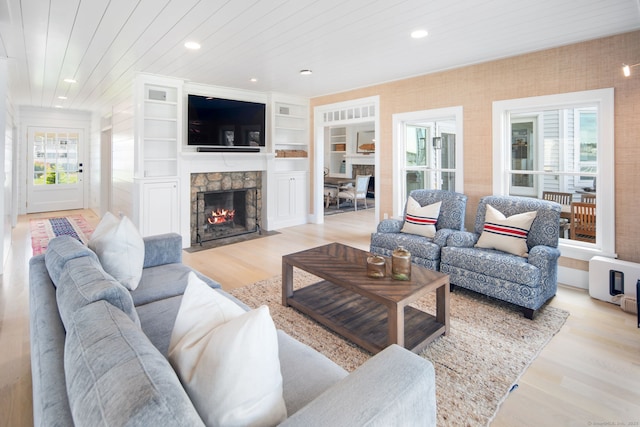 living room with healthy amount of natural light, a fireplace, light wood-style floors, wood ceiling, and recessed lighting