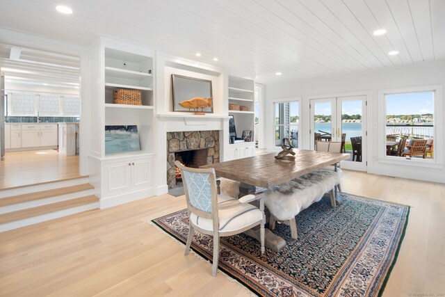 dining space with light wood-style flooring, a fireplace, wood ceiling, recessed lighting, and built in features