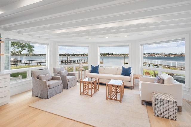 sunroom / solarium featuring beamed ceiling, plenty of natural light, and a water view
