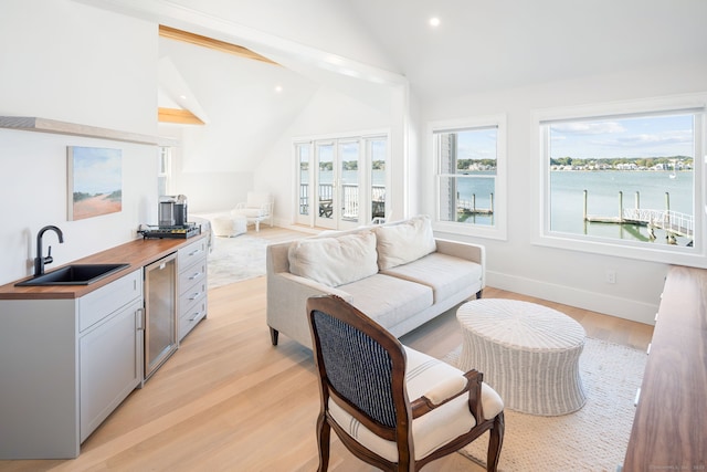 living room with vaulted ceiling, light wood-type flooring, recessed lighting, and baseboards