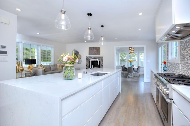 38 Tamarac Rd, Westport, CT 06880 - kitchen with range with two ovens, a sink, light wood-type flooring, open floor plan, and recessed lighting